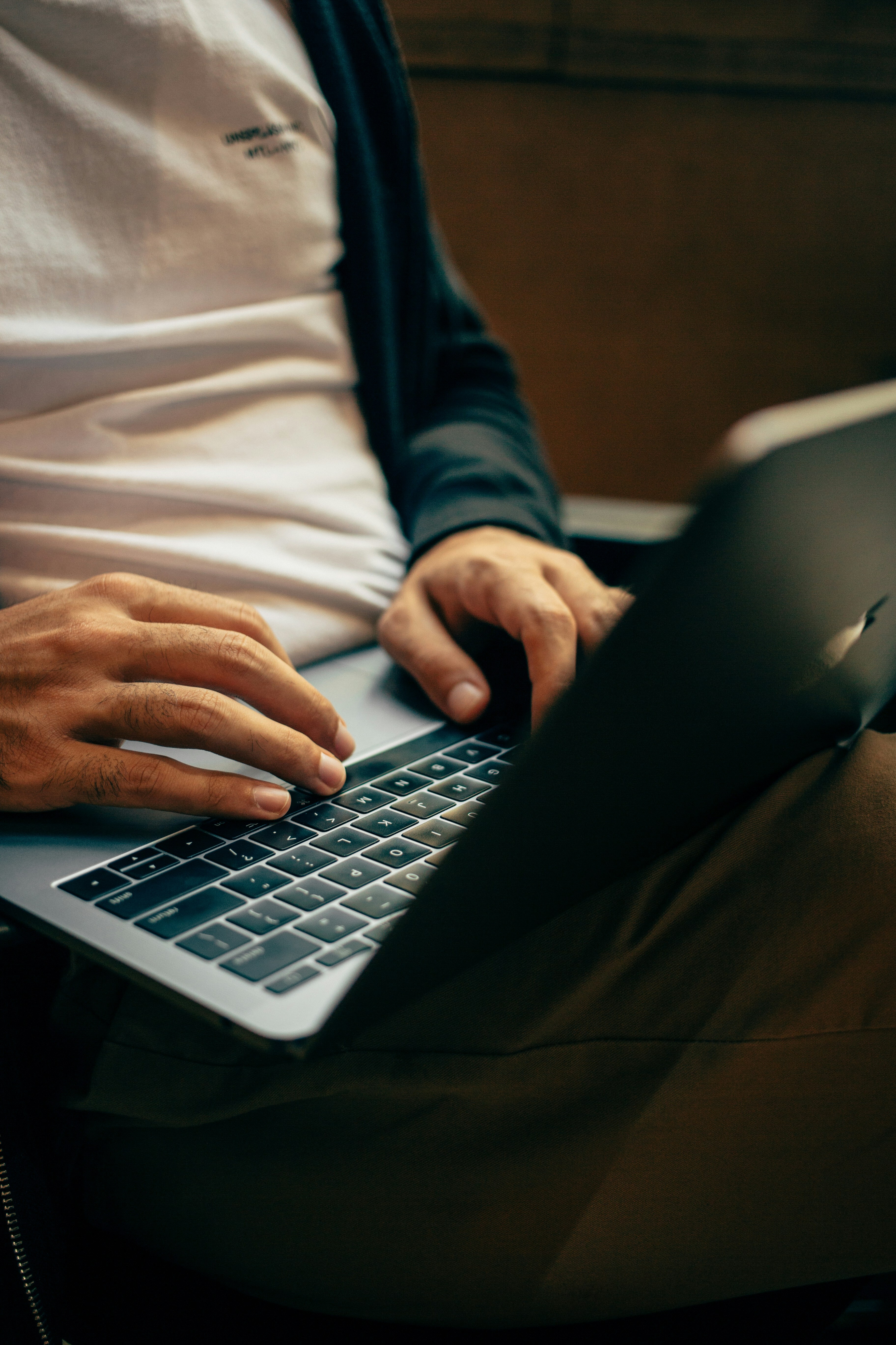 Man typing on computer in his lap